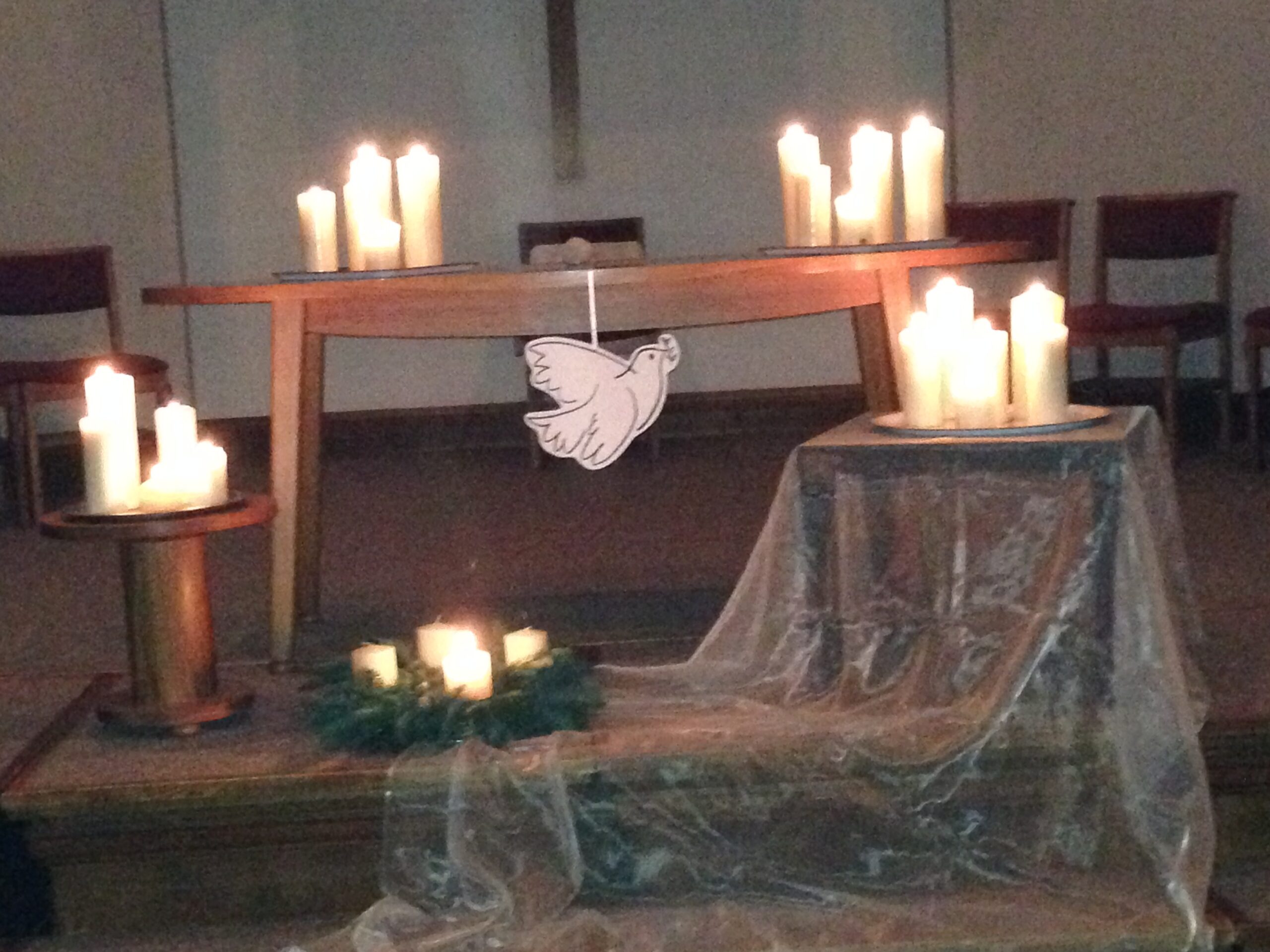Church decorated with candles and dove in low lighting